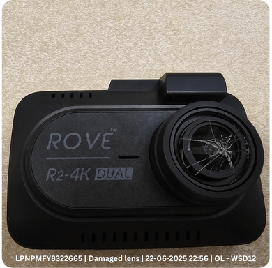 Returned dash cam photographed at intake with a cracked lens, stamped with its LPN, time and warehouse